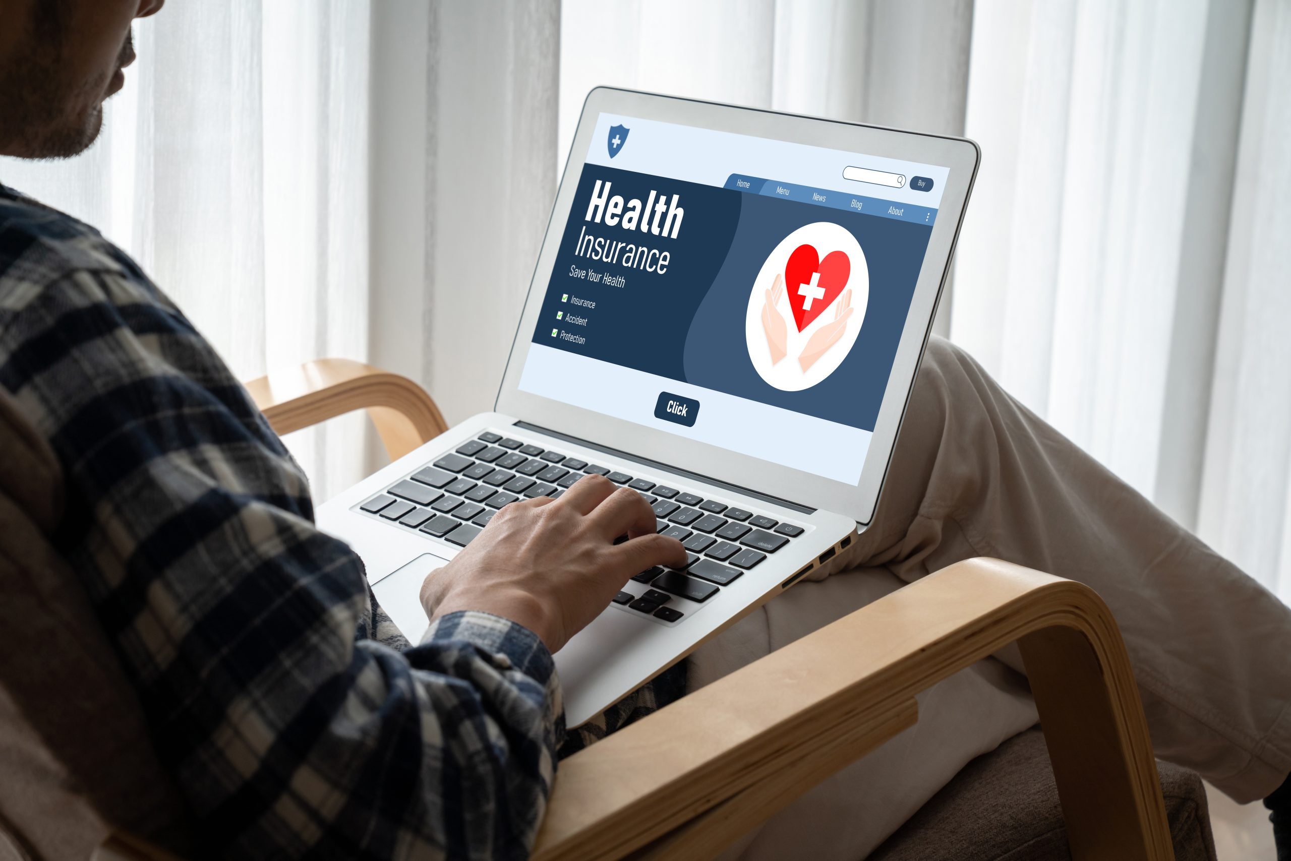 موقع التأمين الصحي الإلكتروني نظام التسجيل الحديث person sitting in a chair with a laptop open looking at a health insurance website